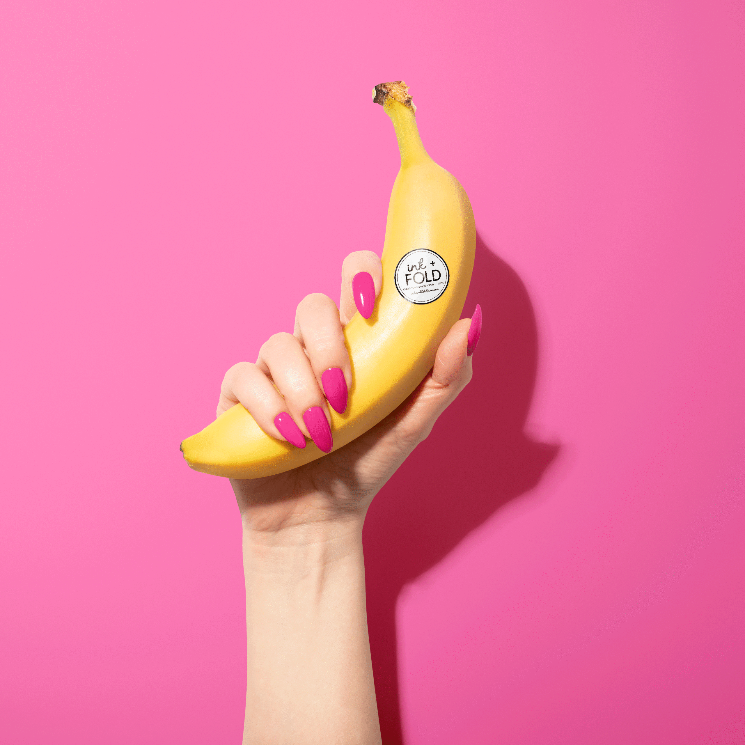 Hand holding a banana with an Ink + Fold sticker